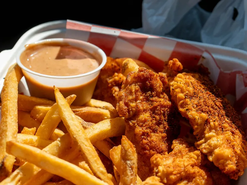 Fried chicken strips and chips in a takeaway box